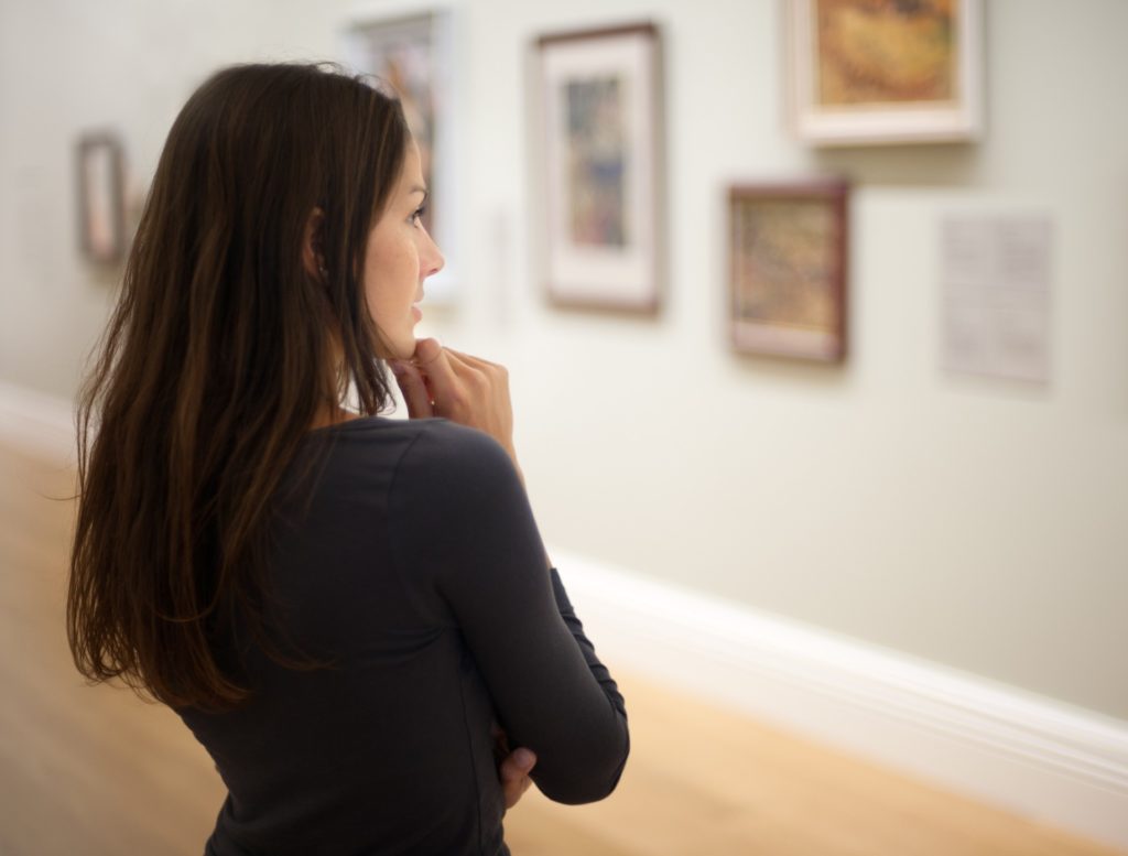 Young Lady Looking at picture on museum