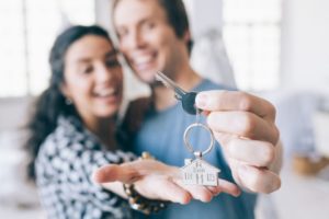 couple cheerful home owners holding a key