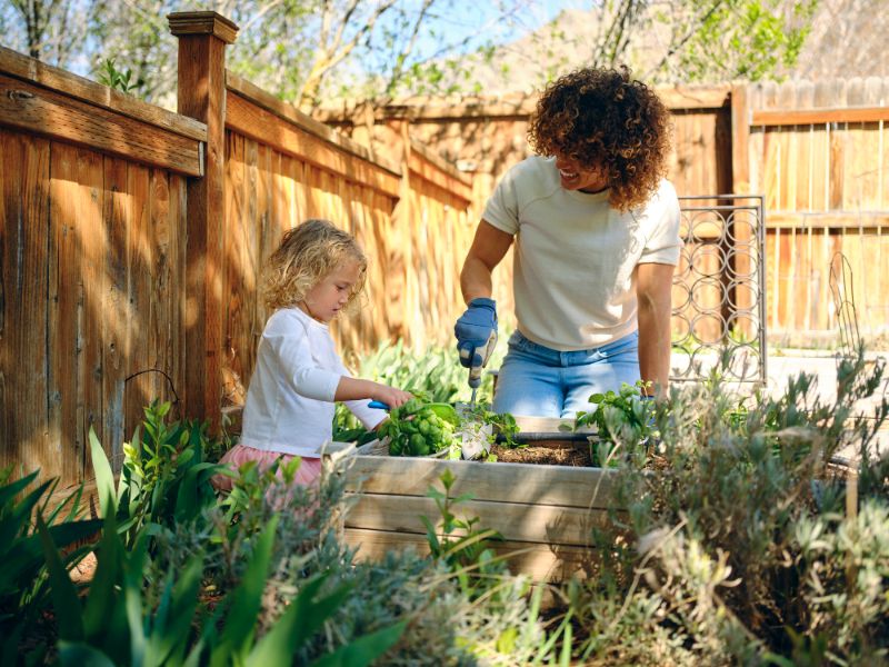 woman and her daughter watering the plants