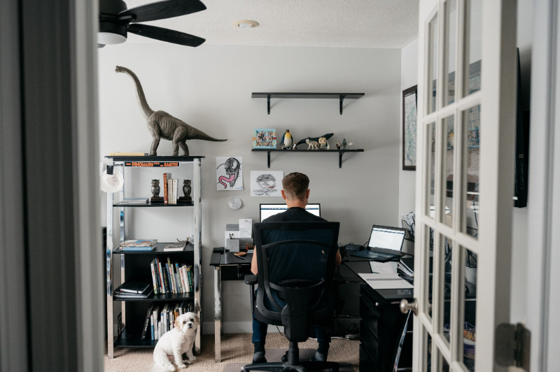 A guy working in his home office and his dog